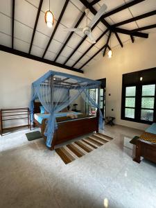 a bedroom with a bed with a blue canopy at Sunbeam Villa in Tangalle +80 photos