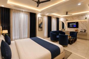 a hotel room with a bed and a desk at Hotel Vibe BLU & Banquet Near Advant, Embassy Oxygen & Sector 142,143 Metro, Noida in Noida