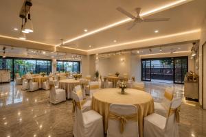 a banquet hall with round tables and white chairs at Hotel Vibe BLU & Banquet Near Advant, Embassy Oxygen & Sector 142,143 Metro, Noida in Noida