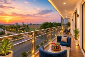 a balcony with a view of the city at sunset at Hotel Vibe BLU & Banquet Near Advant, Embassy Oxygen & Sector 142,143 Metro, Noida in Noida