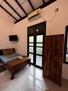 a bedroom with a bed and a tv in a room at Sunbeam Villa in Tangalle