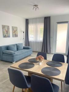 a living room with a table with chairs and a couch at Balatonföldvár Centrum Apartmanok 3 in Balatonföldvár