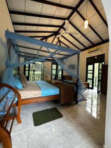 a bedroom with a canopy bed in a room at Sunbeam Villa in Tangalle