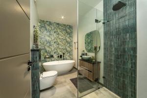a bathroom with a tub and a toilet and a shower at Fifty Ridge in George +89 photos