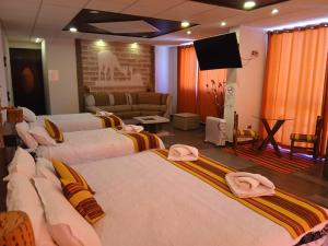 a hotel room with two beds and a flat screen tv at Hotel Cristales De Sal in Uyuni