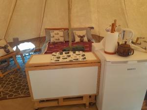 a room with a table and a bed in a tent at Glamping Bell Tent in Norton Saint Philip