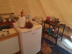 a room with a small refrigerator and a tent at Glamping Bell Tent in Norton Saint Philip