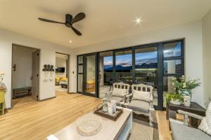 a living room with a ceiling fan and large windows at Fifty Ridge in George