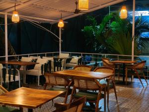 a restaurant with wooden tables and chairs and plants at Studio by Jackfruit in Arambol