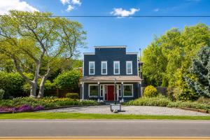 a house with a red door on a street at Seaside Saloon Hot Tub Getaway in Sequim