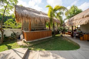 a resort with a bar and a straw hut at The Purple Pineapple Beach Hostel in Kuta Lombok