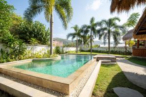 an infinity pool in a backyard with palm trees at The Purple Pineapple Beach Hostel in Kuta Lombok +17 photos