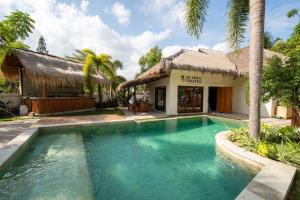a swimming pool in front of a villa at The Purple Pineapple Beach Hostel in Kuta Lombok