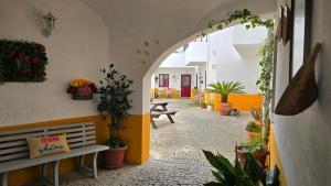 a hallway with a bench and potted plants at Évora City Break Apartment with Patio in the Historic Centre in Évora