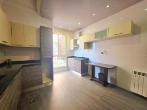 a large kitchen with a wooden table in it at New Halat, Linda in Jbeil