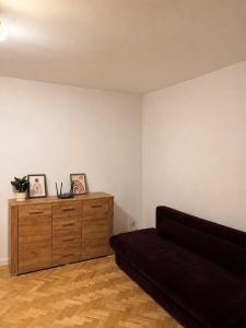 a living room with a couch and a wooden dresser at Apartament 3 Maja in Brodnica