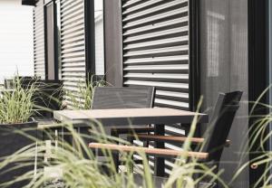 Ein Tisch und Stühle auf einem Balkon mit Pflanzen in der Unterkunft Hotelia in Saint-Ambroise