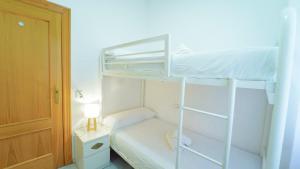 a small bedroom with a bunk bed with a ladder at Bonito y acogedor apartamento pleno centro junto Catedral in Granada +13 photos