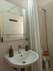 a bathroom with a sink and a shower with a mirror at Feidiou 1, vol I in Egina