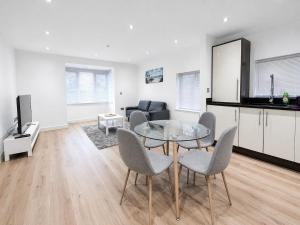 a living room with a glass table and chairs at Relax in a Spacious 2-Bed Pinner Hideaway in Northwood