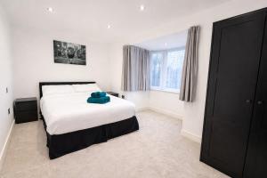 a bedroom with a bed with a blue teddy bear on it at Relax in a Spacious 2-Bed Pinner Hideaway in Northwood