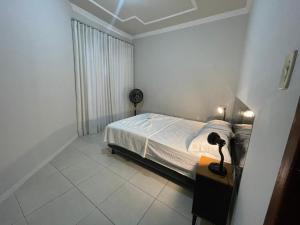 a bedroom with a bed and a lamp on a table at Dali Apart hotel in Ipatinga
