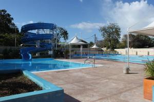 a large swimming pool with a blue water slide at Le Cocon Bleu in Le Moule