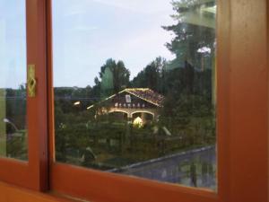 a view of a house through a window at HANNA Pórtico Hotel - Gramado in Gramado