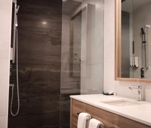 ein Badezimmer mit Dusche, Waschbecken und Spiegel in der Unterkunft Hotelia in Saint-Ambroise + 7 Fotos