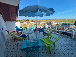 a patio with chairs and tables and an umbrella at Guest house FantasY in Tyulenovo