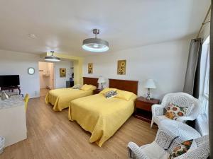 a hotel room with two beds and a tv at Auberge Maison Gauthier in Tadoussac