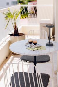 a white table with two glasses of wine on it at Quartier hippodrome in Cagnes-sur-Mer
