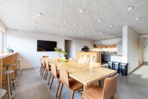 a dining room with a large wooden table and chairs at Tech Spa Coliving&Coworking Spaces in Druskininkai