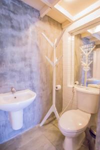 a bathroom with a white toilet and a sink at Atlas Bangkok Hotel in Bangkok +93 photos
