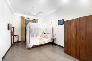 a bedroom with a bed with a mosquito net at Luminara Sky Lounge with Pool near Ahangama Beach in Ahangama