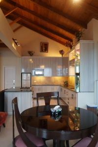 a kitchen with a table and chairs in a kitchen at Wisteria Cottage in Dunga Gali +4 photos