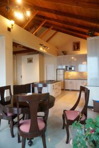 a kitchen with a table and some chairs and a table and a kitchen at Wisteria Cottage in Dunga Gali
