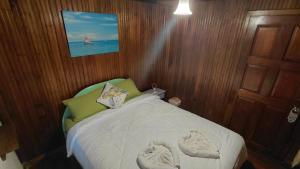 a small bedroom with a bed with towels on it at Tortugas Brews B&B in Bocas Town
