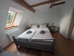 a bedroom with a bed with white sheets and a window at Zum altem Forsthof Grittel in Grittel