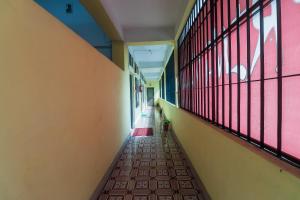 an empty hallway of a school with windows and a plant at Hotel O SPRINGVILLA in Dispur