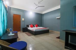 a bedroom with a bed with blue walls and red pillows at Hotel O SPRINGVILLA in Dispur