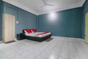 a bedroom with a bed in a blue wall at Hotel O SPRINGVILLA in Dispur +38 photos