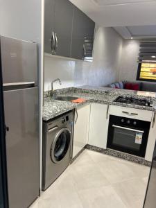 a kitchen with a washing machine and a sink at عروس النخيل in Tétouan