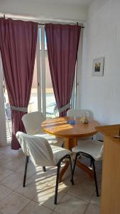 a dining room with a table and two chairs at Slavica Bunić, Apartments in Supetarska Draga