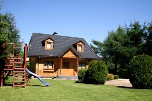 a log house with a slide and a playground at Domki w Bieszczadach in Polańczyk