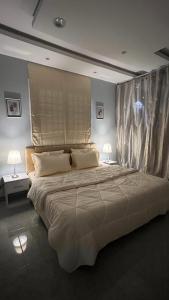 a large bed in a bedroom with two lamps at شقة ريفالا الفاخرة in Abha