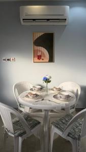 a white dining room table with chairs and a white table at شقة ريفالا الفاخرة in Abha