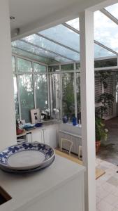 un salón acristalado con una mesa con un plato. en Villa des iris, en París
