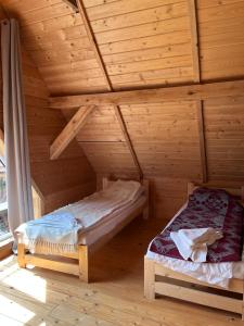 a room with two beds in a log cabin at Wioska Mnicha - Dom na końcu in Knyszyn