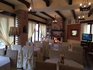 restauracja z białymi stołami i krzesłami oraz kominkiem w obiekcie Green Hotel - Maravel Botanical Garden w mieście Spílion